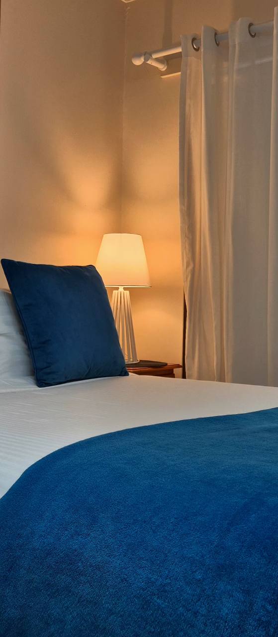 Warm bedside lighting and blue cushions